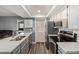 Bright kitchen features stainless steel appliances, gray cabinets and countertops, and wood-look floors at 520 N Stapley Dr # 256, Mesa, AZ 85203