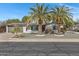 Charming single-story home featuring mature palm trees, a well-maintained yard, and solar panels on the roof at 5232 E Dodge St, Mesa, AZ 85205