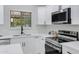 Beautiful white kitchen featuring stainless steel appliances, and sleek countertops for a modern and functional space at 5232 E Dodge St, Mesa, AZ 85205