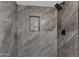 Close-up of shower featuring marble tile, shower niche, and rainfall shower head at 5232 E Dodge St, Mesa, AZ 85205
