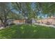 Landscaped backyard featuring a lush lawn, mature shade trees, and a cozy outdoor lounge area at 530 W Almeria Rd, Phoenix, AZ 85003