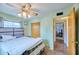 Bright bedroom with a ceiling fan, closet and door to a room with a TV at 5410 E University Dr, Mesa, AZ 85205