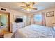 Cozy bedroom featuring modern dresser and a large mirror, illuminated by natural light from a window at 5410 E University Dr, Mesa, AZ 85205
