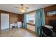 Spacious bonus room with a window, tile floors, wood paneling and blue curtains at 5410 E University Dr, Mesa, AZ 85205
