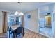 Dining area with sleek table and chairs, adjacent to a sliding glass door and an opening to the kitchen at 5410 E University Dr, Mesa, AZ 85205