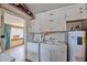 Functional laundry room with washer, sink, and storage cabinets, conveniently located with water heater at 5410 E University Dr, Mesa, AZ 85205