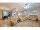 Open-concept living room featuring wood-look floors, multiple seating areas, and seamless flow to other rooms at 5410 E University Dr, Mesa, AZ 85205