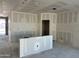 The unfinished living room reveals blank drywall, pre-installed utilities, and a bright window showcasing construction at 5515 W Piedmont Rd, Laveen, AZ 85339