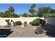 Desert landscaping in the backyard features cacti, bushes and trees, complemented by a stucco wall and natural rock at 5526 N 77Th Way, Scottsdale, AZ 85250