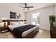 Well-lit bedroom with wooden bed frame, ceiling fan, and views of desert landscape at 5526 N 77Th Way, Scottsdale, AZ 85250