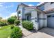 Charming front entrance with a blue door, arched entryway, lush landscaping, and a concrete walkway at 567 E Tropical Dr, Casa Grande, AZ 85122