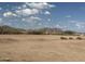 Vast desert landscape featuring native vegetation with mountain views in the distance under a partly cloudy sky at 567 E Tropical Dr, Casa Grande, AZ 85122