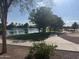 Winding path around a beautiful pond with mature trees and lush landscaping at 567 E Tropical Dr, Casa Grande, AZ 85122