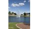 Serene pond reflecting the sky with a central fountain, framed by green grass and mature trees at 567 E Tropical Dr, Casa Grande, AZ 85122