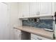 Laundry room featuring sleek cabinetry, ample countertop space, and a decorative tile backsplash at 5815 E Nora St, Mesa, AZ 85215