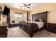 Main bedroom with ceiling fan, a large bed and bay window with seating area at 5815 E Nora St, Mesa, AZ 85215