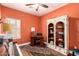 Office room with hardwood floor, orange walls, an antique desk and a book shelf at 5815 E Nora St, Mesa, AZ 85215