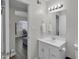 Clean bathroom with a white vanity, bright lighting, and a view to the dining area at 6416 S Kenneth Pl # D, Tempe, AZ 85283