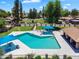 Community pool with blue umbrellas, lounge chairs, landscaping, and a view of surrounding green space at 6416 S Kenneth Pl # D, Tempe, AZ 85283