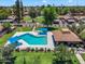 Aerial view of a community pool and recreation area surrounded by lush grass and charming residential buildings at 6416 S Kenneth Pl # D, Tempe, AZ 85283