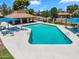 Aerial view of a sparkling community pool with lounge chairs and shade umbrellas on a sunny day at 6416 S Kenneth Pl # D, Tempe, AZ 85283