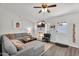 Bright living room featuring a comfortable gray sectional sofa, fireplace, and ceiling fan at 6416 S Kenneth Pl # D, Tempe, AZ 85283