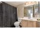 Functional bathroom featuring a single vanity and shower; bright lighting at 6516 E Rochelle St, Mesa, AZ 85215