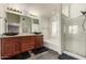 Bathroom with dual sinks, dark wood cabinets, separate shower, and soaking tub at 6516 E Rochelle St, Mesa, AZ 85215