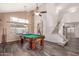 Bright, open game room featuring a pool table, vaulted ceilings, a ceiling fan, and seamless access to the stairs at 6516 E Rochelle St, Mesa, AZ 85215