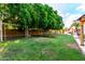Lush backyard featuring a playset and trampoline surrounded by mature trees and green grass at 7029 E Monte Cir, Mesa, AZ 85209