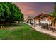 This spacious backyard features green grass, shade trees, a play area, gazebo, and inviting landscaping at 7029 E Monte Cir, Mesa, AZ 85209