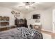 The bedroom includes a ceiling fan, neutral walls, and a queen-sized bed with grey bedding and a vanity at 7029 E Monte Cir, Mesa, AZ 85209