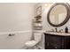 Stylish powder room featuring a dark wood vanity with marble countertop, round mirror, and decorative wall shelves at 7029 E Monte Cir, Mesa, AZ 85209