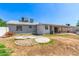 Back of house with a large backyard and a small brick patio on a sunny day at 7047 W Almeria Rd, Phoenix, AZ 85035