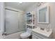 Bathroom featuring a shower over bath with a sliding glass screen and a white vanity unit at 7102 E Kalil Dr, Scottsdale, AZ 85254