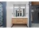 Modern bathroom featuring a double vanity, stylish lighting, and walk-in shower with blue tile at 7102 E Kalil Dr, Scottsdale, AZ 85254