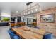 Bright dining room with a rustic wooden table, blue chairs, and exposed brick accent wall at 7102 E Kalil Dr, Scottsdale, AZ 85254