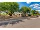 Charming one-story home with mature trees, desert landscaping, and a tranquil street view at 7102 E Kalil Dr, Scottsdale, AZ 85254