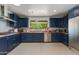 Well-lit kitchen featuring dark blue cabinets, butcher block countertops, and stainless steel appliances at 7102 E Kalil Dr, Scottsdale, AZ 85254
