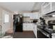 Cozy kitchen featuring white cabinets, black appliances, and access to the backyard at 7102 E Kalil Dr, Scottsdale, AZ 85254