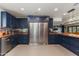 Large kitchen with dark blue cabinets, butcher block countertops, and stainless steel refrigerator at 7102 E Kalil Dr, Scottsdale, AZ 85254