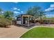 Cozy backyard shed with a small deck and seating area, surrounded by mature trees at 7102 E Kalil Dr, Scottsdale, AZ 85254