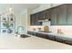 Modern kitchen featuring a large island with a sink and stainless steel appliances and gray cabinets at 7330 E Vista Bonita Dr, Scottsdale, AZ 85255