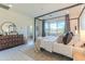 Light-filled main bedroom features a four-poster bed, dresser, and access to an en-suite bathroom at 7330 E Vista Bonita Dr, Scottsdale, AZ 85255