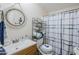 Nautical-themed bathroom features a round decorative mirror, toilet, and a shower with a blue and white shower curtain at 7807 E Main St # H-27, Mesa, AZ 85207