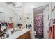 Well-organized bathroom featuring a vanity with a sink, shelves, and a shower with a decorative floral curtain at 7807 E Main St # H-27, Mesa, AZ 85207