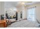 Bright bedroom featuring a comfortable bed, sitting area, large window with sheer curtains, and ceiling fan at 7807 E Main St # H-27, Mesa, AZ 85207