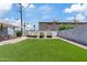 Wide shot of the backyard featuring a manicured artificial lawn and a detached covered seating area at 818 W Earll Dr, Phoenix, AZ 85013