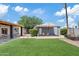 Wide angle shot of backyard featuring artificial lawn, covered patio, and detached structure at 818 W Earll Dr, Phoenix, AZ 85013