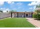 Charming backyard featuring a covered patio, manicured artificial lawn, and modern landscaping at 818 W Earll Dr, Phoenix, AZ 85013
